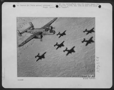 Thumbnail for Consolidated > North American B-25  "Mitchell" flys over North African desert enroute to the target for the day. Note shadows cast by preceding formation. North Africa.