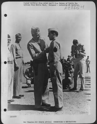 Consolidated > S/Sgt. John Nappi, gunner of Brooklyn, N.Y. receiving the Silver Star from Lt. General Frank M. Andrews, Commanding General of U.S. Army Forces in the Middle East. Making an individual run on Tobruk Harbor his ship was ripped in numerous places by