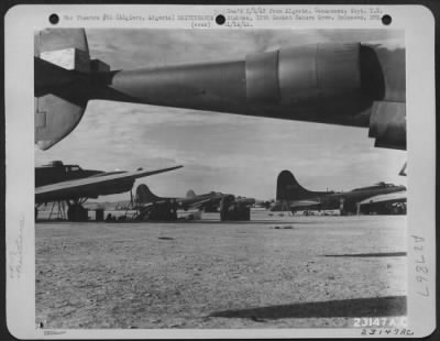 Thumbnail for Consolidated > Boeing B-17 "Flying Fortresses," parked on an airfield near Algiers, Algeria, are serviced by ground crew men.