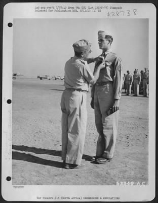 Consolidated > S/Sgt. Leonard J. Stevens, Sandy Valley, Ariz., receiving the Distinguished Flying Cross from Maj. Gen. Lewis H. Brereton.