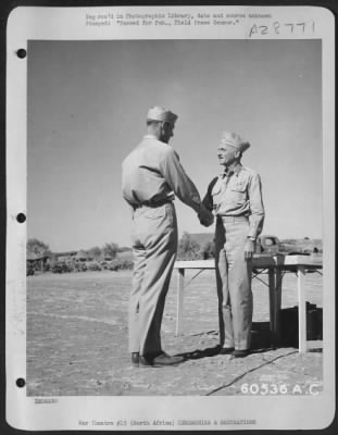 Consolidated > One of the most honored soldiers in North Africa was S/Sgt. Benjamin J. Warmer, left, who is shown being congratulated by Lt. General Carl. A. Spaatz, Commanding General of the Northwest African Air Force, upon having been presented the Distinguished