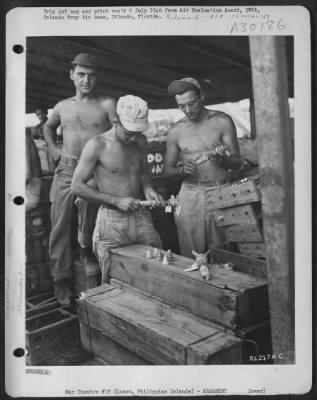 Thumbnail for Consolidated > Armament men putting detonators in the #112 fuses prior to fusing the bombs. After this operation has been completed, the bombs and fuses are then taken to the plane where the ordnance men place the fuses in the tail of the bombs. Clark Field, Manila