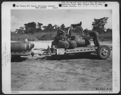 Thumbnail for Consolidated > By using a special hoist and truck, AAF personnel load 1000 pound bombs onto a trailer. Bomb Storage and supply dump, Clark Field, Luzon, Philippine Islands. 1 June 1945.