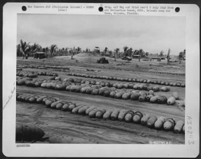 Consolidated > Grade 3 GP bombs to be renovated at Lingayen Airdrome, Luzon, in the Philippine Islands. Notice the AA gun position and gun crews quarters in the background. 12 June 1945.