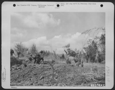 Consolidated > The line moves forward as men scurry up a ridge to forward positions in the face of heavy Jap fighting. They are taking up a small mortar in an effort to flush the Japs on the other side of the ridge. The battle for Fort Stotsenburg and hills beyond