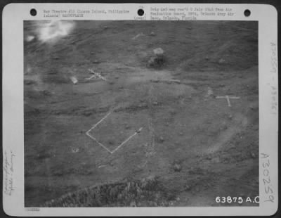 Thumbnail for Consolidated > An aerial view of a Jap dummy airfield in the Clark Field area. Three dummy airplanes, a dummy tower and a marker indicating the end of the runway can be seen in this photo. January 1945.