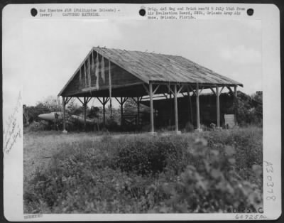 Thumbnail for Consolidated > This photograph of a Japanese aircraft repair shop was taken at the south end of Licanan Airdrome, Mindanao, in the Philippine Islands. The plane shown in the background was a complete wreck, but engines and repair facilities in the back part of the