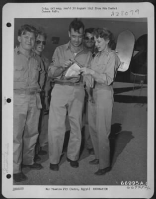 Thumbnail for Consolidated > Anna Lee, a member of the Jack Benny show troupe, autographs a slip of paper for an unidentified sergeant at Heliopolis Airport, just out of Cairo, Egypt.