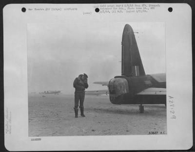 Thumbnail for Consolidated > A pilot leans against the wind as he makes his way to a shelter during a sand storm at a landing ground in Libya.