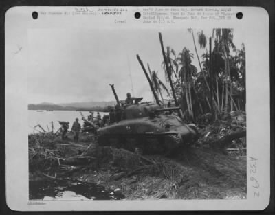 Consolidated > Landing at Hollandia in Humboldt Bay, New Guinea on 22 April 44. Tank rumbles inland to attack Jap positions.