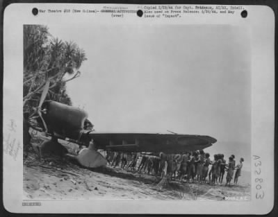 Thumbnail for Consolidated > Japanese Aichi 99 "Val" is dragged up on a New Guinea Beach by Natives, "Bongs" for Technical Intelligence Officers.