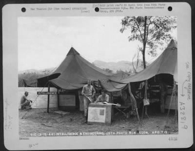 Thumbnail for Consolidated > Men of the Intelligence and Engineering Section of the 25th Photo Reconnaissance Squadron, 6th Photo Reconnaissance Group, with the 5th Air Force, interrogating crews at a base somewhere in New Guinea.