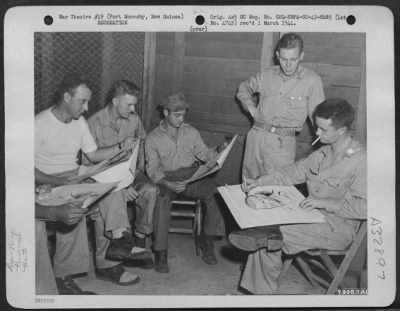 Thumbnail for Consolidated > John McCormack of the American Red Cross explains the technique of making crayon drawings to Major Emmett S. Davis of Compton, California, commanding officer of the 35th Fighter Squadron, 8th Fighter Group at Port Moresby, New Guinea. Looking