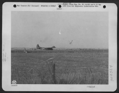 Consolidated > A troop transport, right, plunges to earth in Holland during landing of the 1st Allied Airborne Army. Crew members are coming to earth under 'chutes, faintly discernible. 23 September 1944.