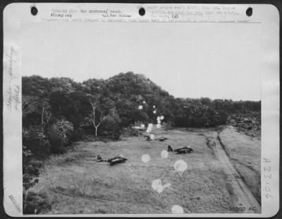 Thumbnail for Consolidated > Fragmentation bombs dropped by parachute take their toll in destruction of grounded Japanese aircraft and installations on the But airdrome. This raid was one of the heavy blows dealt the enemy recently in the But and Wewak areas.