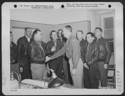 Thumbnail for Consolidated > Major Walter Lund, San Diego, Calif., is congratulated by Brig. General Carlyle H. Ridenour, Pasadena, Calif., after he was presented the Legion of Merit at an air base in the Mediterranean Area. In the background, looking on are, left to right: Lt.