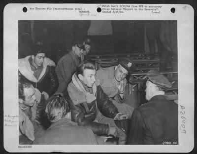 Consolidated > Returned from a large-scale bombing raid on an aircraft factory in Austria, this American crew attached to the Mediterranean Allied Air Forces is interrogated about the mission. Three generals are in the picture. Asking a question, his back to the