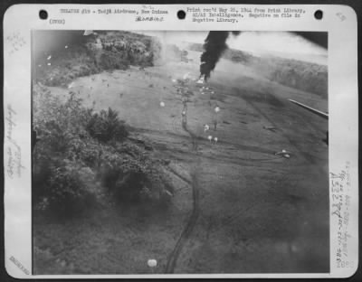 Thumbnail for Consolidated > In a raid on Tadji Airdrome in Northern New Guinea, 13 February 1944, parachute bombs wrought havoc on Jap aircraft parked along the strip. In the upper center of the picture, the funeral pyre of a Jap bomber can be seen.