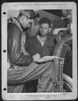 ENGLAND-T/Sgt Charles E. Edwards, 24, Cordele, Ga., flight engineer on "Flying Crusader" checks perofrmance of plane ofllowing mission with M/Sgt John Coltran. The two have a conference every time the plane lands, and usually Edwards gives good - Page 1