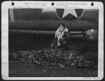 Thumbnail for Gunner > S/Sgt. Robert L. Taylor kneeling next to a pile of empty .50 cal. Machine gun shells.