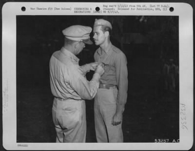 Consolidated > Capt. Clayton L. Peterson (right) was one of 16 pursuit pilots decorated at ceremonies held in New Guinea on the eve of their departure for the United States to take up new air corps assignments. He is shown receiving the Distinguished Flying Cross