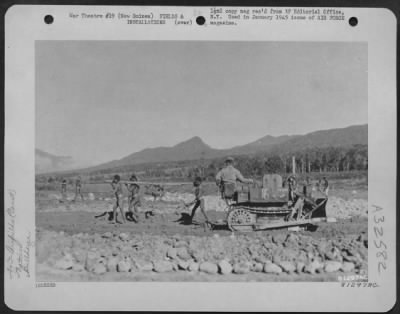 Thumbnail for Consolidated > During The Construction Of Eunice Airstrip In New Guinea, Native Labor Was Recruited To Help Build The Strip.  The Natives Shown In This Photo Are Carrying Rocks To Be Used In Constructing The Runway.  The Bulldozer Was Used For Clearing The Strip And Lev