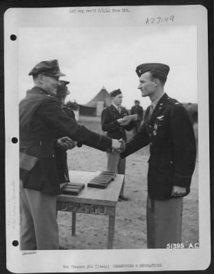 Thumbnail for Consolidated > With the Distinguished Flying Cross pinned to his tunic, 1st Lt. Sammy E. McGuffin, 1737 10th St., Manhatten Beach, Calif., is shown here being congratulated by Col. Charles W. Lawrence, Commanding Officer of an AAF Wing, who made the presentation