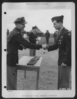 Thumbnail for Consolidated > With the Distinguished Flying Cross pinned to his tunic, 1st Lt. Hugh L. Thompson, 116 N. McKinnley, Harrisburg, Ill., is shown here being congratulated by Col. Charles W. Lawrence, Commanding Officer of an AAF Wing, who made the presentation to the