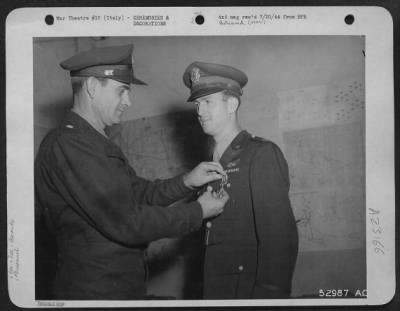 Consolidated > Gen. J. H. Atkinson pins on DFC for participation on Weiner-Neustadt raid which was highly successful. The recipient is Navigator Capt. Benjamin W. Jones, of Washington, Ga.