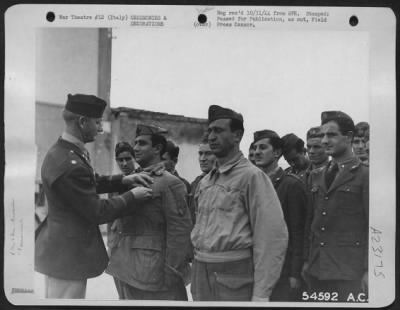 Thumbnail for Consolidated > Lt. Col. Joseph G. Russell, of San Antonio, Texas, Commanding Officer of a Liberator Bomber Group, pins the soldiers Medal on Sgt. Major Santo Tedono, an Italian soldier who was born in White plains, N.Y. With Sgt. Major Nicola Surdo, (standing at