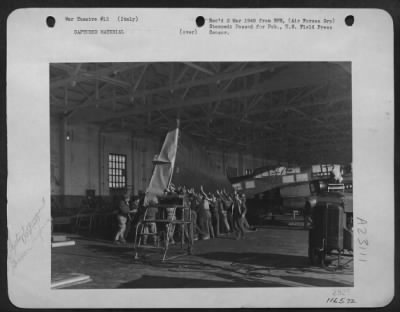 Thumbnail for Consolidated > G.I. Mechanics Of An Aircraft Assembly Squadron In Italy And Italian Laborers Prepare A Wing Of The Heinkel 111 For Shipment To The United States.  The German Bomber Landed In Italy.