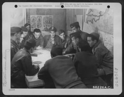 Thumbnail for Consolidated > Major Ashley E. Wooldridge of Clearfield, Penna. (right, lower face hidden), group operations officer of a medium bomber group of the 12th Air Force, points out a tentative axis of attack to flight leaders who will participate in the raid. Sardinia