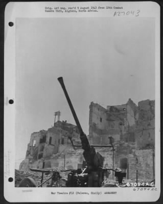 Thumbnail for Consolidated > An American ack-ack gun, surrounded by bomb damaged buildings, is ready to go into action in case the enemy stages a surprise attack on installations at Palermo, Sicily. July 1943.