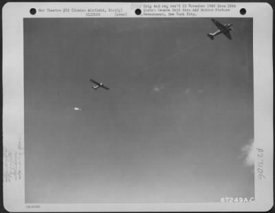 Thumbnail for Consolidated > A parachute is attached to the landing gear which was just been released from the glider, airborne over Comiso Airfield, Sicily, during 52nd Troop Carrier Wing maneuvers in 1943. The gear has been dropped so that the glider will make a skid landing