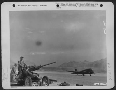 Thumbnail for Consolidated > A 40Mm Ack-Ack Gun And Its Crew Is Prepared To Defend This Airfield On Sicily In The Event Of A Surprise Attack.  July 1943.  Note The Douglas C-47 On The Runway.