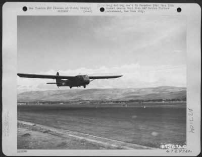 Thumbnail for Consolidated > A Waco Cg-4 Glider, Loaded With Guns, Is Airborne Over Runway At Comiso Airfield, Sicily, During Maneuvers In 1943.