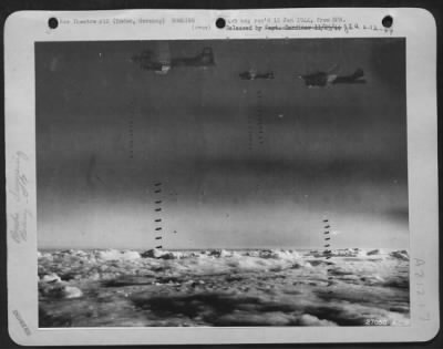 Thumbnail for Consolidated > Taken from an 8th Air Force Bomber Command Boeing B-17 Fortress during an attack on the important port of Emden, 2 October, 1943, shows three Flying Fortresses over the target for "bomb away." In the foreground two sticks of bombs just begin to nose