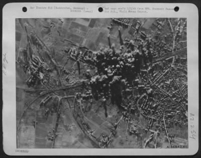 Thumbnail for Consolidated > For the sixth consecutive day, U.S. 8th Air Force heavy bombers struck at Nazi supply lines feeding Rundstedt's divisions just behind the battle lines. Here smoke from heavy concentrations of bombs cover the rail marshalling yards at Euskirchen