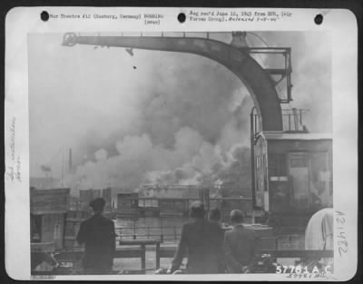 Consolidated > German Caption Writers Wrote On This Picture -------'...Der Deutschen Werfe In Flammen.  Flames And Smoke Fill The Sky Around The Deutsche Werkes Where Submarines Were Under Construction.  German On-Lookers Stand By, Watching The Spectacle Of Devastation