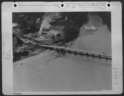 Thumbnail for Consolidated > An 1100 Foot Wooden Vehicular Bridge At Wan-Lai-Kam, Burma, During An Attack By 14Th A.F. Lightnings.  A Fire Bomb Dropped By The P-38 Can Be Seen Directly Over The Bridge.  Plume Of Smoke, From A Near Miss, Rises At Right Upper Of Photo.  This Bridge Was