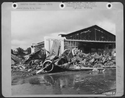 Thumbnail for Consolidated > Heap Of Demolished Planes And Wrecked Hangar In Background, Wheeler Field, T.H.  Army Amphibian In Foreground.