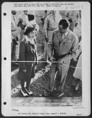 Consolidated > Mrs. Ulysess S. Miller Watches Colonel Earl H. Jacobsen, Wing Commander, Wheeler Field, As He Cuts The Tape And Officially Opens Service Club 2, At The Grand Opening, Saturday, June 28, 1947.    Credit: 'Army Air Forces Photo., Wash. D.C.'