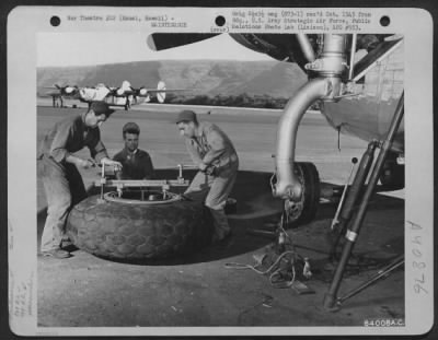 Thumbnail for Consolidated > Men Of The 864Th Bomb Squadron, 494Th Bomb Group Change One Of The Big Tires On A Consolidated B-24 Liberator At The Barking Sands Airstrip On Kauai, Hawaii.  They Are, Left To Right:  Sgt Milton S. Nygaard Of Salem, Oregon; Tsgt Merle E. Anderson Of Toll