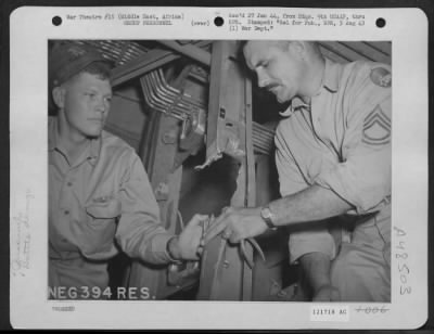 Thumbnail for Groups > Tsgt Fred D. Randall Of Amarillo, Texas, Engineer Of A Liberator Struck By Enemy Ack-Ack Over Italy Shows 1Lt Melvin E. Neef Of Houstonia, Missouri, The Pilot, How He Closed The Hydraulic Line With Pliers, While Being Drenched With Gasoline From The Punct