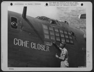 Thumbnail for ␀ > Cew Chief Of The Consolidated B-24 Liberator 'Come Closer' Paints The 91St Bomb On Nose Of The Plane Ti Indicate The Missions That The Plane Has Flown.  The Three Jap Flags Painted On The Plane Indicates That Its Crew Has Shot Down 3 Jap 'Zeros'.  Saipan,